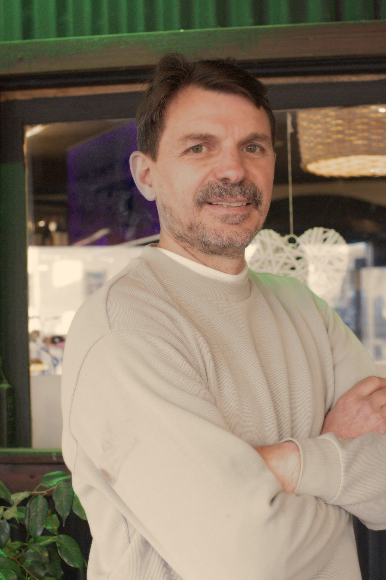 Javier, dueño y chef de La Birra, posa con los brazos cruzados frente a la entrada del restaurante